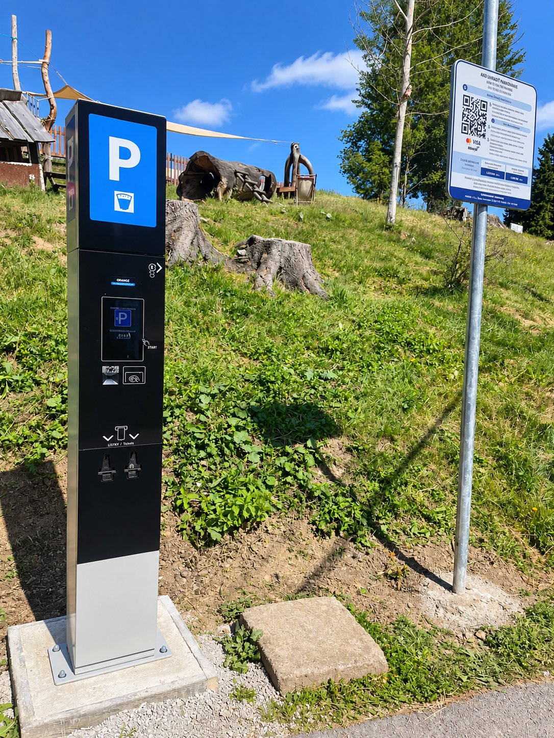 Parkovací automat na kopci s výhľadom na obec